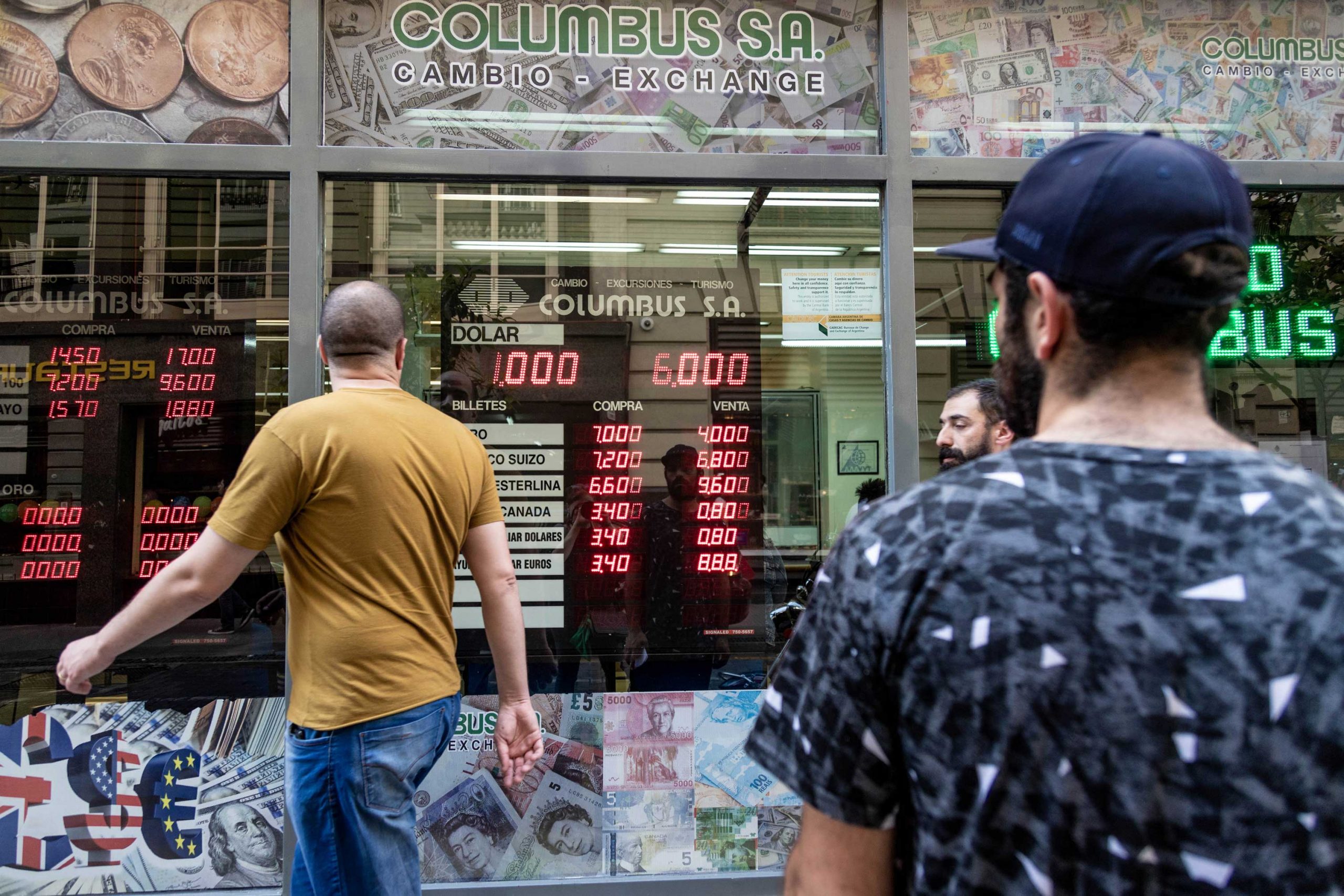 Men walking past a foreign exchange kiosk